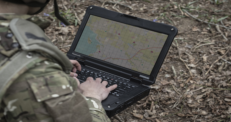 Man using a rugged Panasonic Toughbook that has been tested to MIL-STD-810 classification during a military operation.