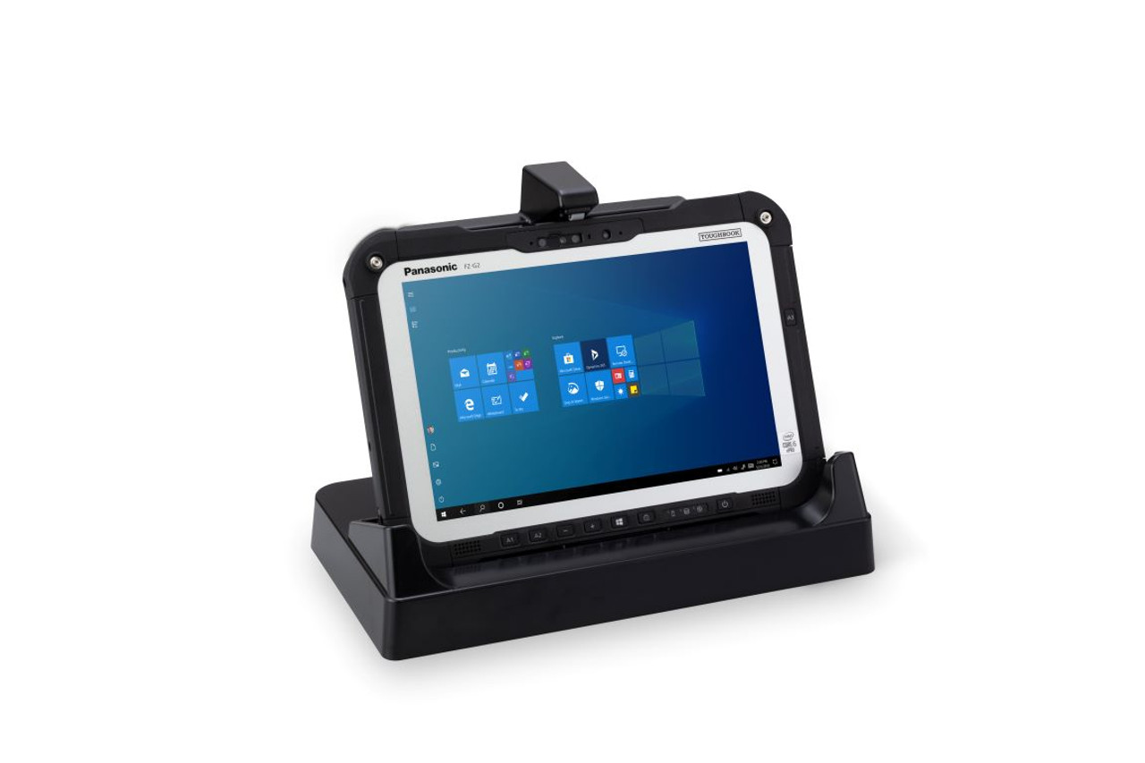 A rugged tablet being placed into an office docking station