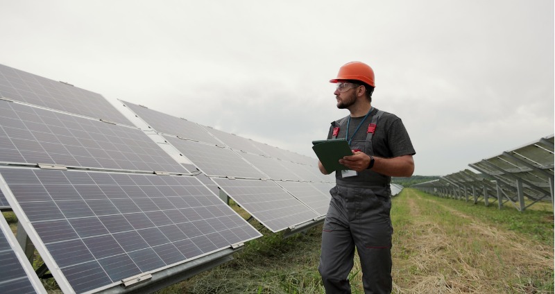 A worker in a solar farm using a tablet with high battery life.