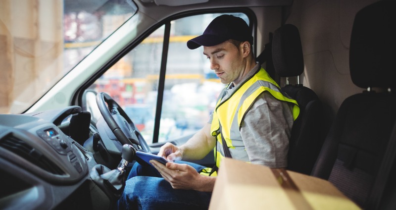 Delivery driver using a mobile device management system on his tablet.