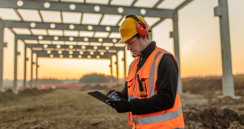 Man using a tablet fitted with an intrinsically safe case while on site.