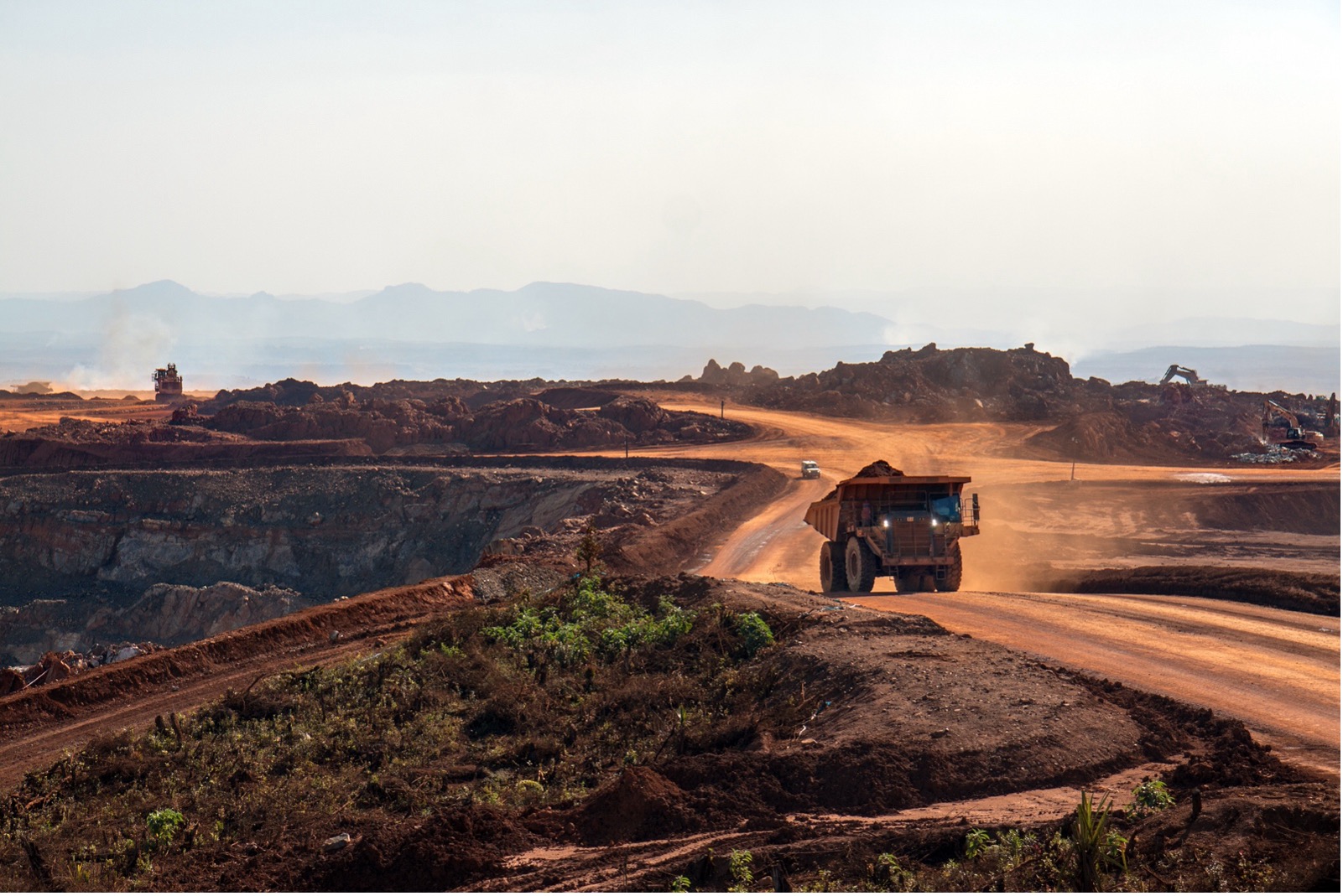 Large mining truck driving along a dusty road in a remote open-pit mine, highlighting the need for reliable mobile signal boosters in harsh Australian work environments
