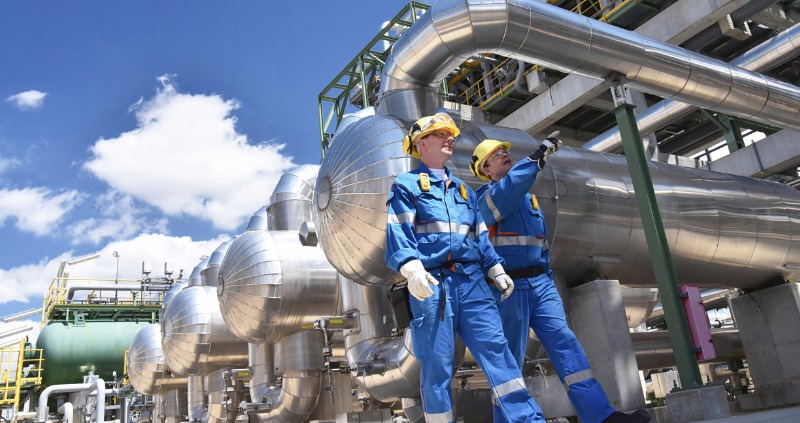 two industrial workers properly certified in a refinery with machinery 