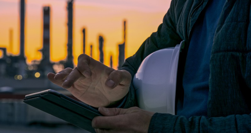 A field worker using a rugged android tablet on a oil & gas plant 